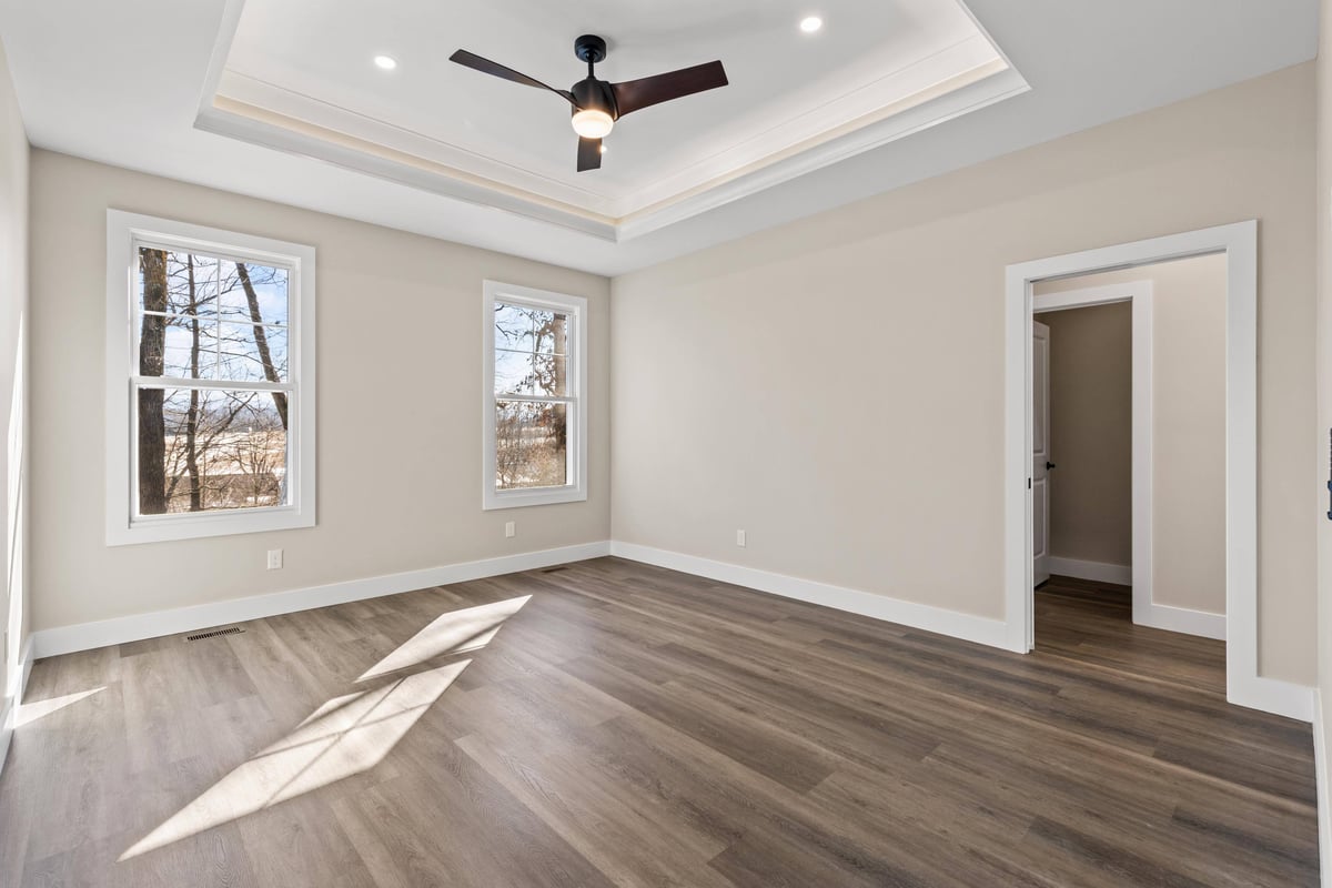 Bright bedroom with tray ceiling and hardwood flooring in a custom home in Knoxville, TN by Debuty Builders, Inc.