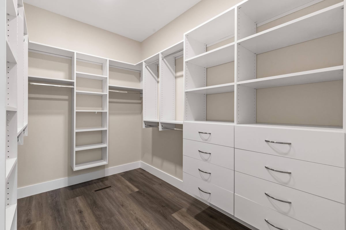 Custom walk-in closet with white shelving and drawers, offering organized storage in a custom home in Knoxville, TN by Debuty Builders, Inc.