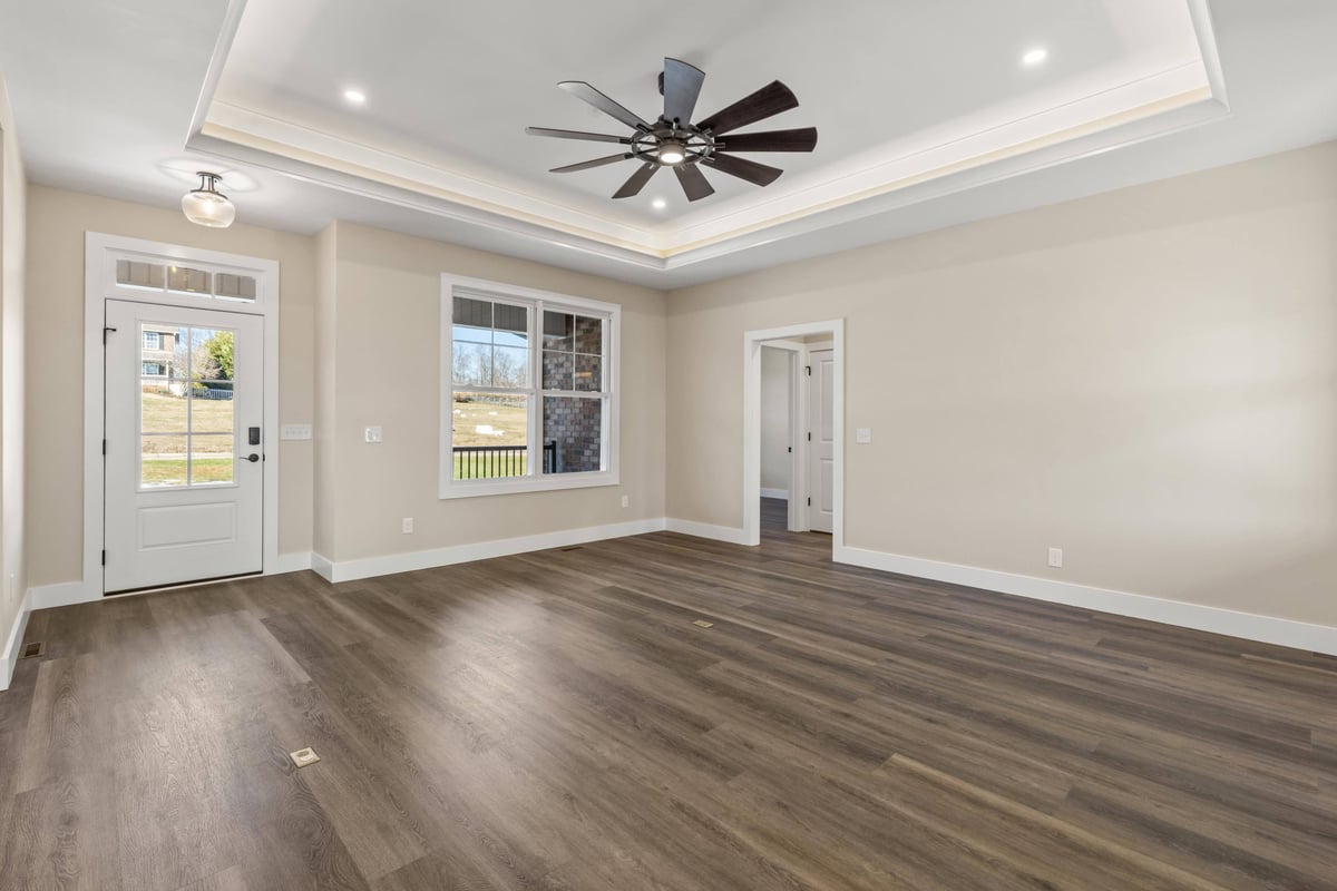 Interior of a custom home in Knoxville, TN by Debuty Builders, Inc., with tray ceilings, recessed lighting, and hardwood floors