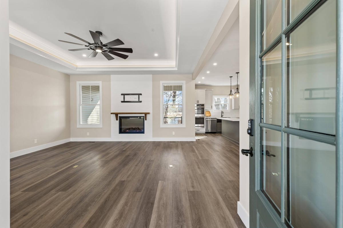 Open living area of a custom home in Knoxville, TN by Debuty Builders, Inc., showcasing modern floors, a ceiling fan, and large windows