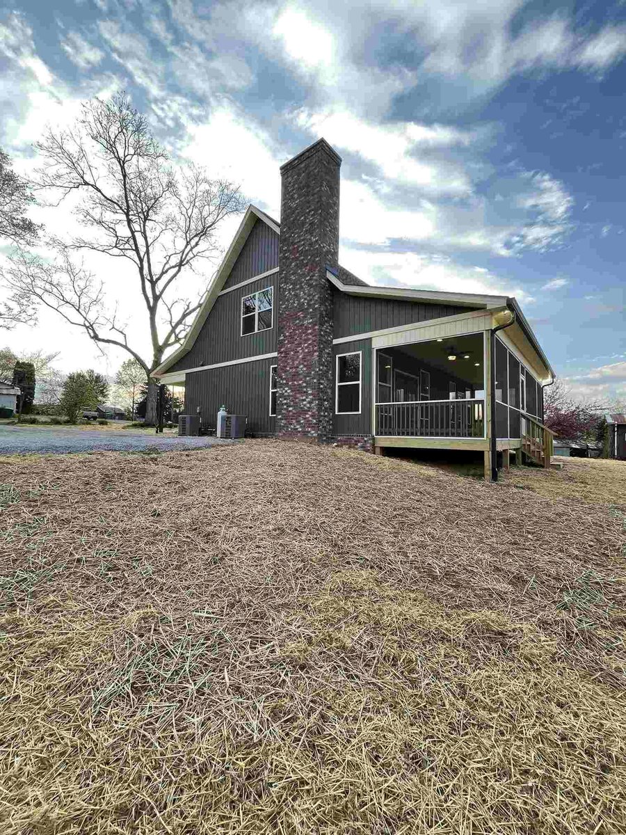 Backyard view of custom-built home with tall chimney by Debuty Builders in Knoxville, TN