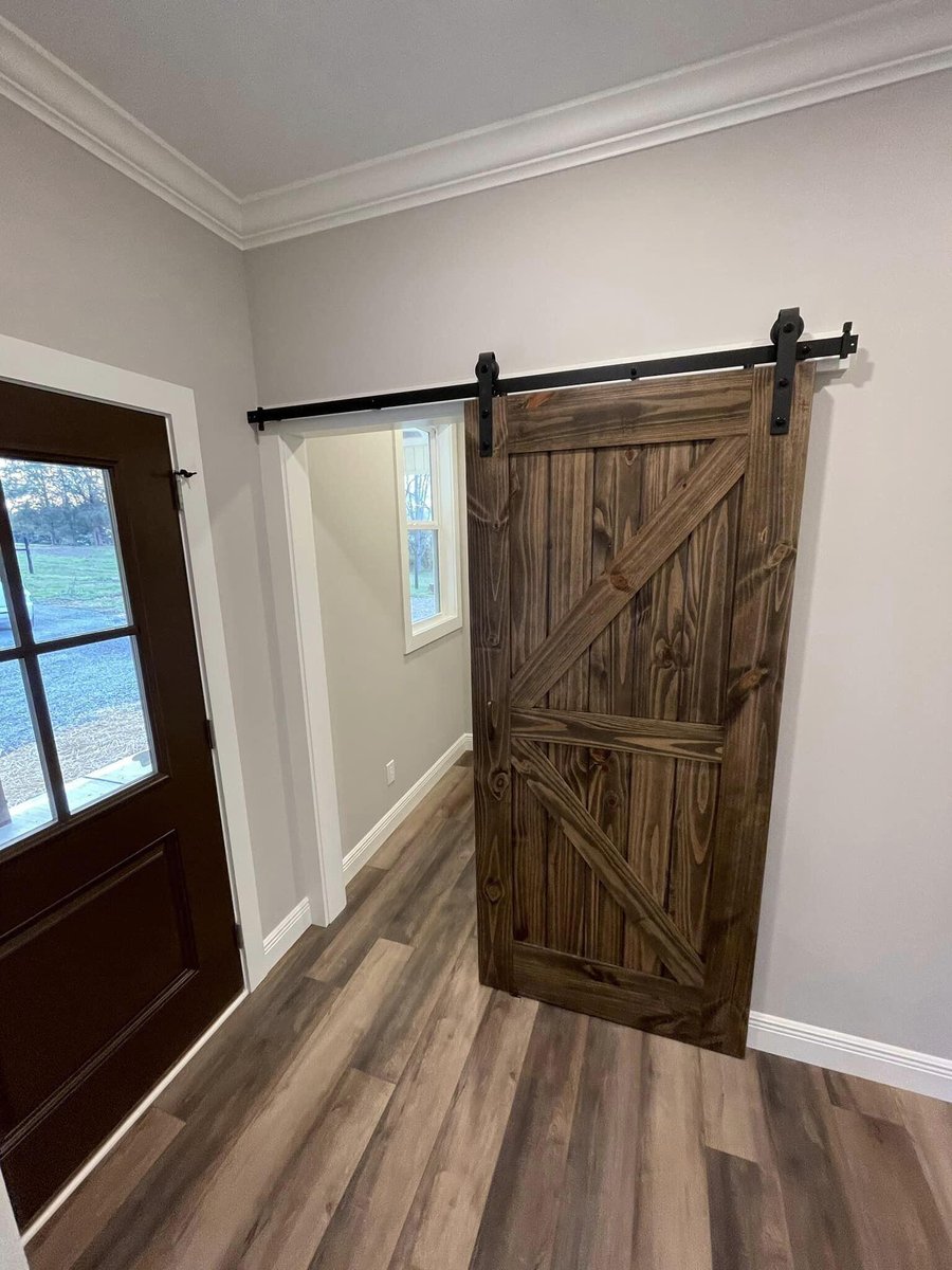 Entryway of custom-built home with dark wood barn door by Debuty Builders in Knoxville, TN