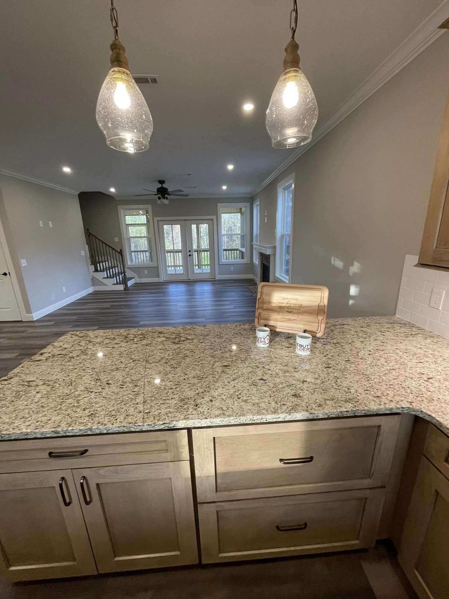 Kitchen island with granite countertop and view of the living room in a custom home by Debuty Builders, Knoxville, TN