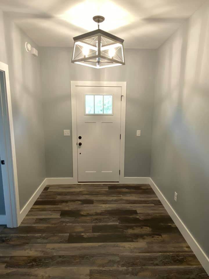 Entryway with modern light fixture and wood flooring in custom home by Debuty Builders, Knoxville, TN