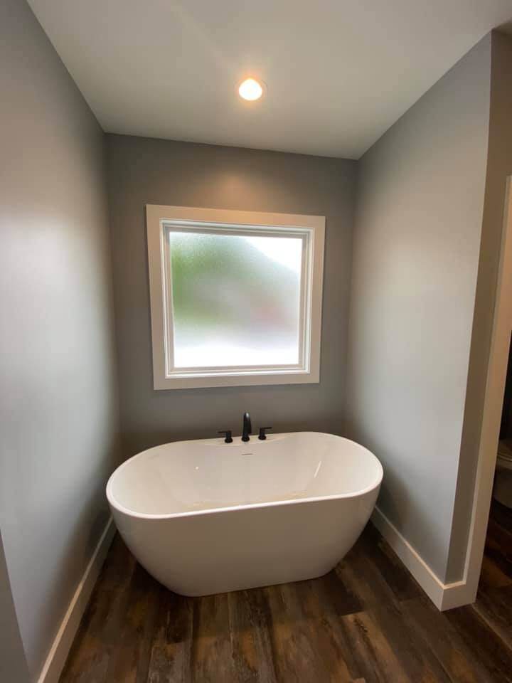 Freestanding bathtub under frosted window in custom bathroom by Debuty Builders, Knoxville, TN
