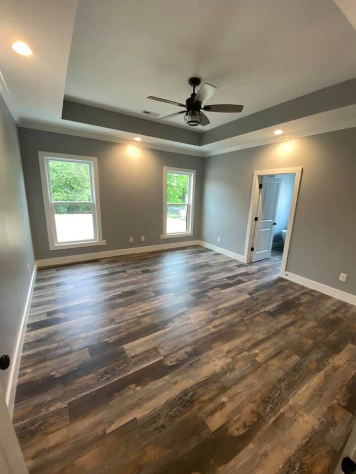 Master bedroom with tray ceiling and hardwood floors in Debuty Builders custom home, Knoxville, TN