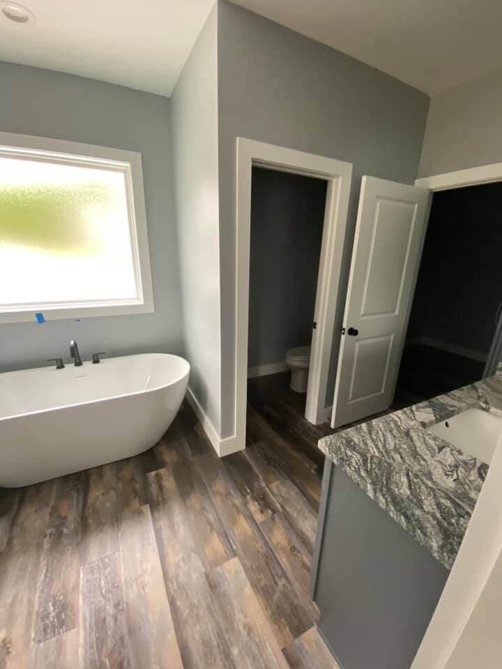 Modern bathroom with freestanding tub and granite vanity in custom home by Debuty Builders, Knoxville, TN