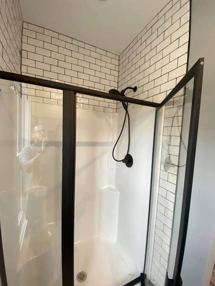 Shower with white subway tiles and glass enclosure in custom home by Debuty Builders, Knoxville, TN