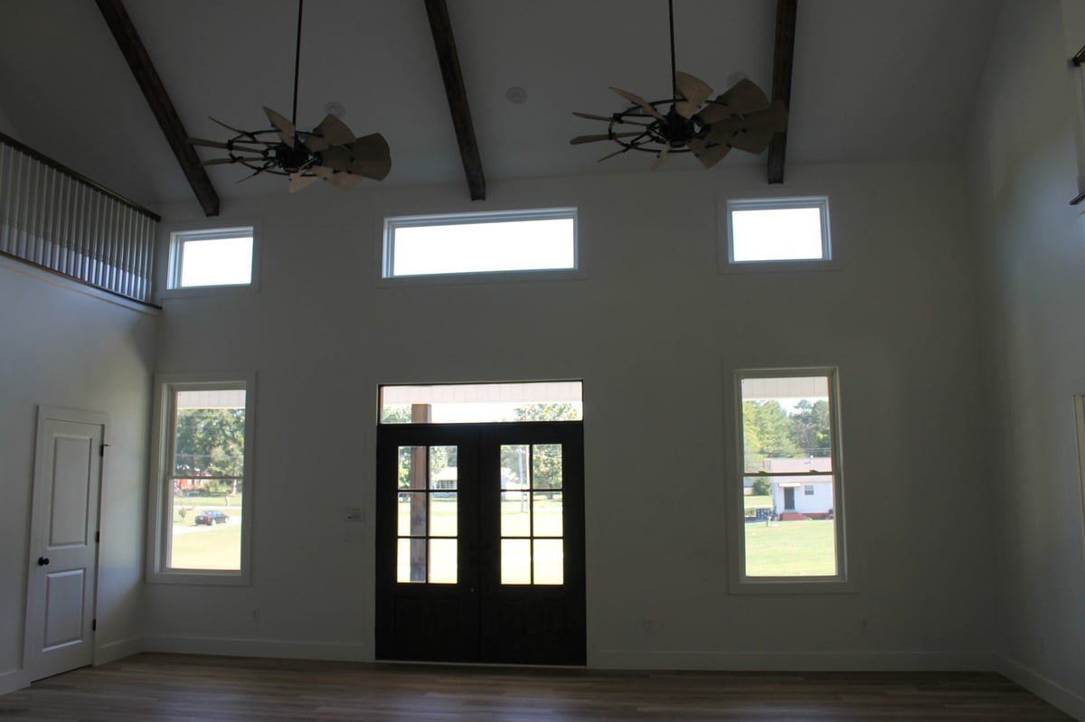 Custom home interior with high ceilings, large windows, and modern ceiling fans by Debuty Builders, Knoxville, TN