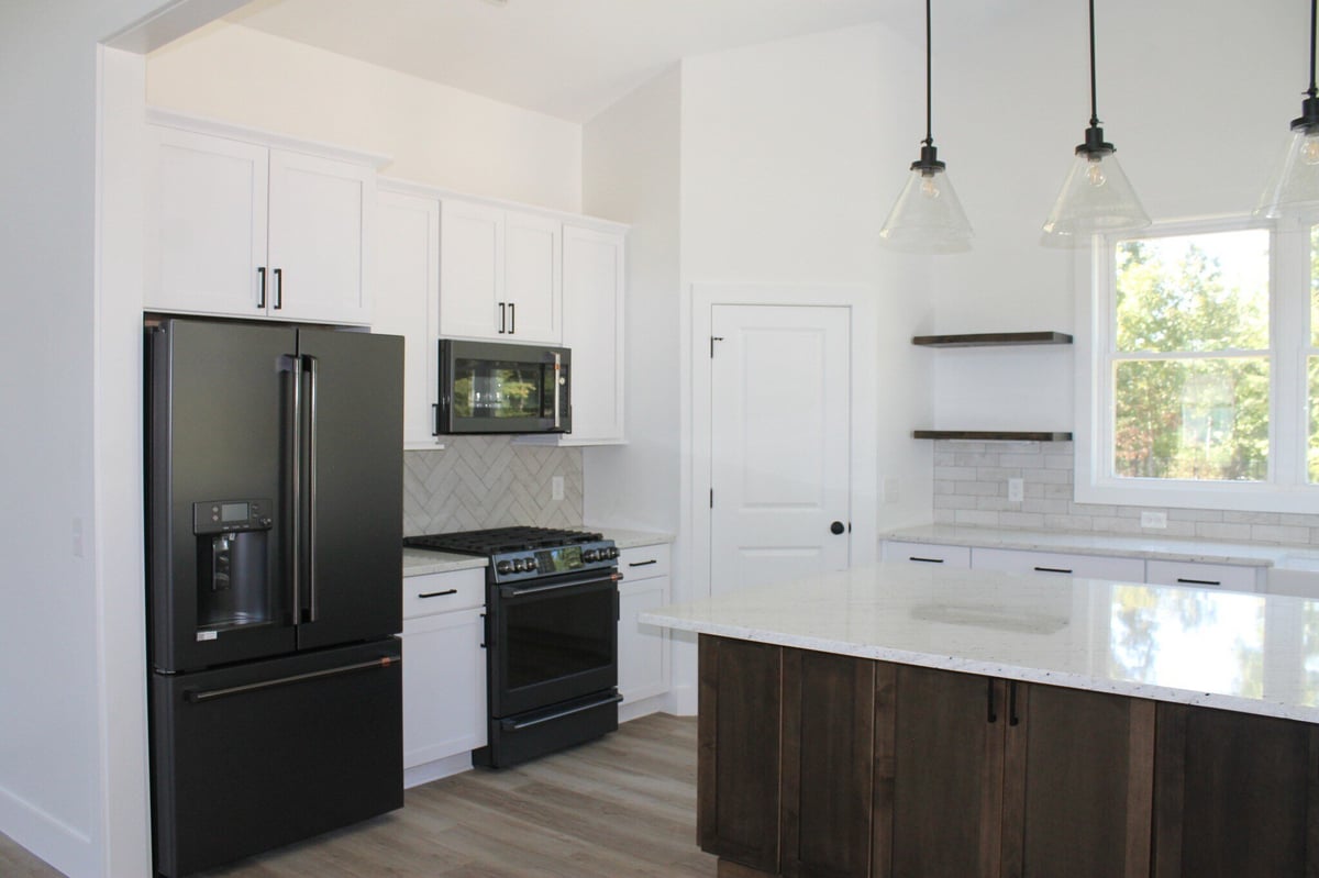 Custom kitchen with white cabinets and black appliances by Debuty Builders in Knoxville, TN