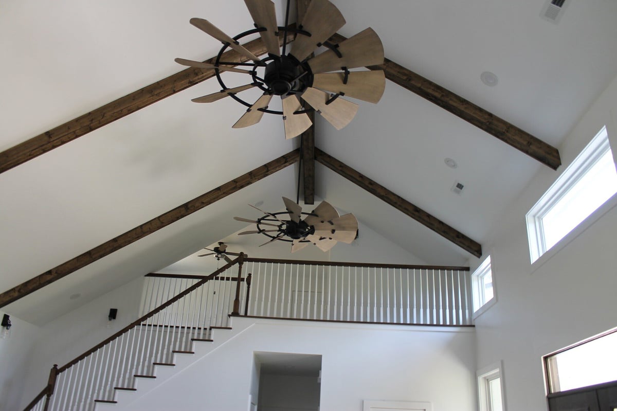 Interior view of vaulted ceiling with exposed wood beams and unique ceiling fans in a custom home by Debuty Builders, Knoxville, TN