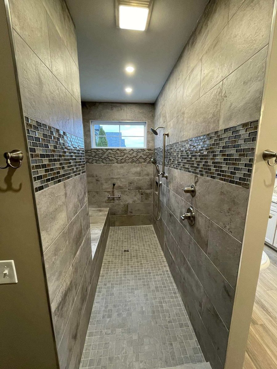 Custom shower with intricate tile work and multiple showerheads in Knoxville, TN by Debuty Builders