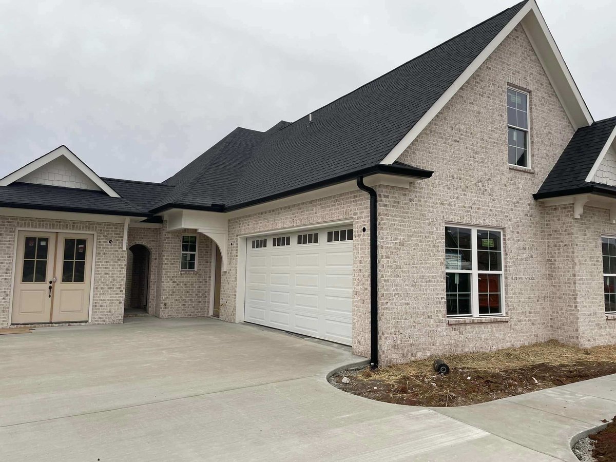 Front driveway and white brick exterior of a custom home in Knoxville, TN by Debuty Builders