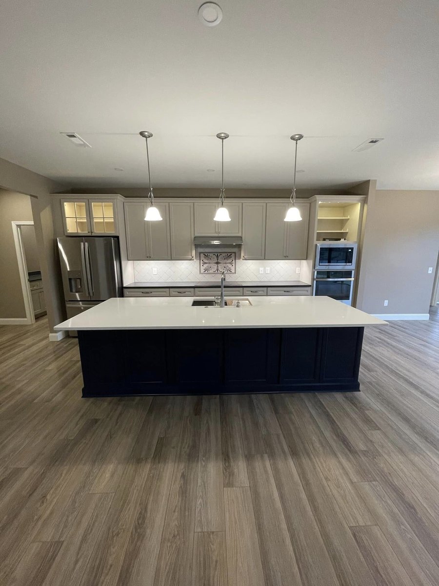 Newly finished kitchen with a large island and pendant lights in a custom home by Debuty Builders in Knoxville, TN