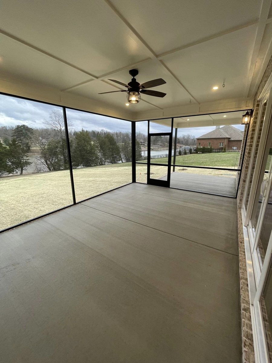 Screened-in patio with ceiling fan overlooking a custom home yard in Knoxville, TN by Debuty Builders