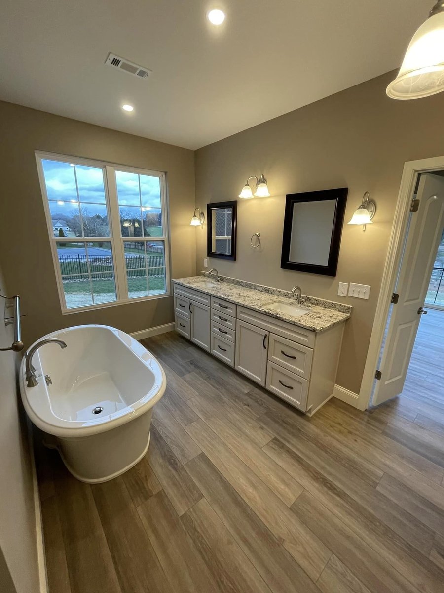 Spacious master bathroom with a freestanding tub and double vanity in Knoxville, TN by Debuty Builders