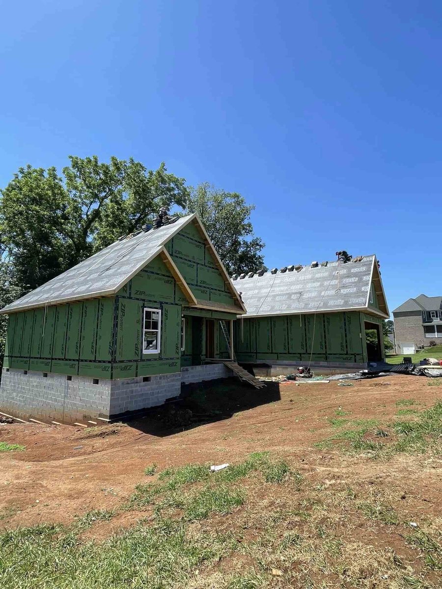 Exterior view of roof installation and green exterior wrap for custom home by Debuty Builders in Knoxville, TN