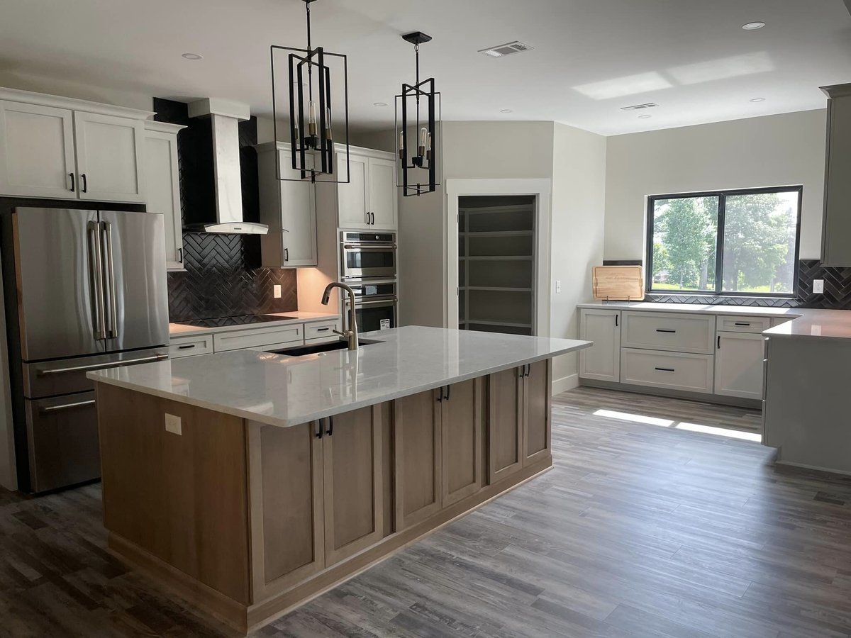 Contemporary kitchen with a large island and modern lighting by Debuty Builders in Knoxville, TN