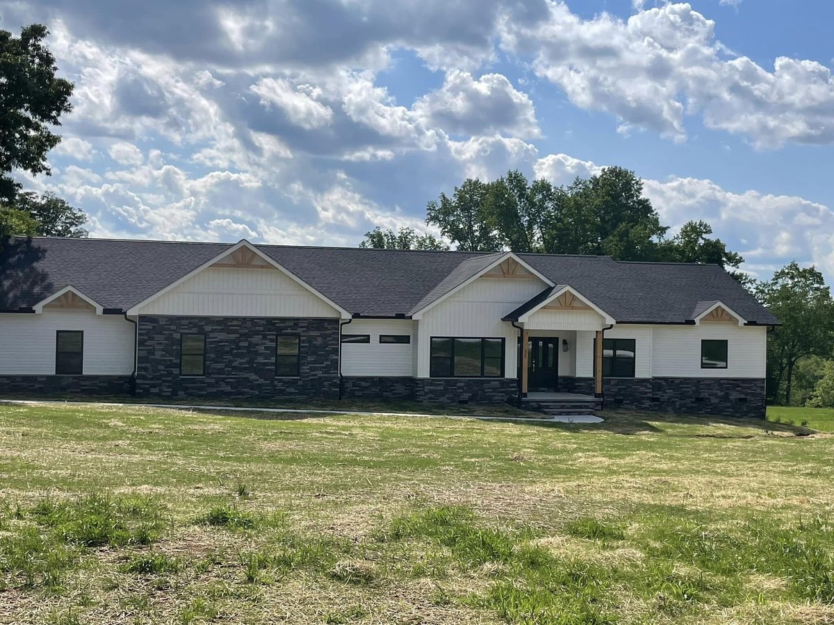 Front exterior view of a custom-built home by Debuty Builders in Knoxville, TN, with a stone facade