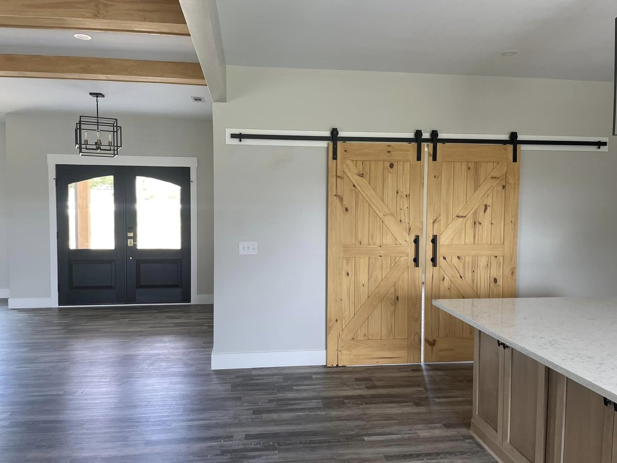 Laundry room with custom cabinetry and black washer-dryer units by Debuty Builders, Knoxville, TN