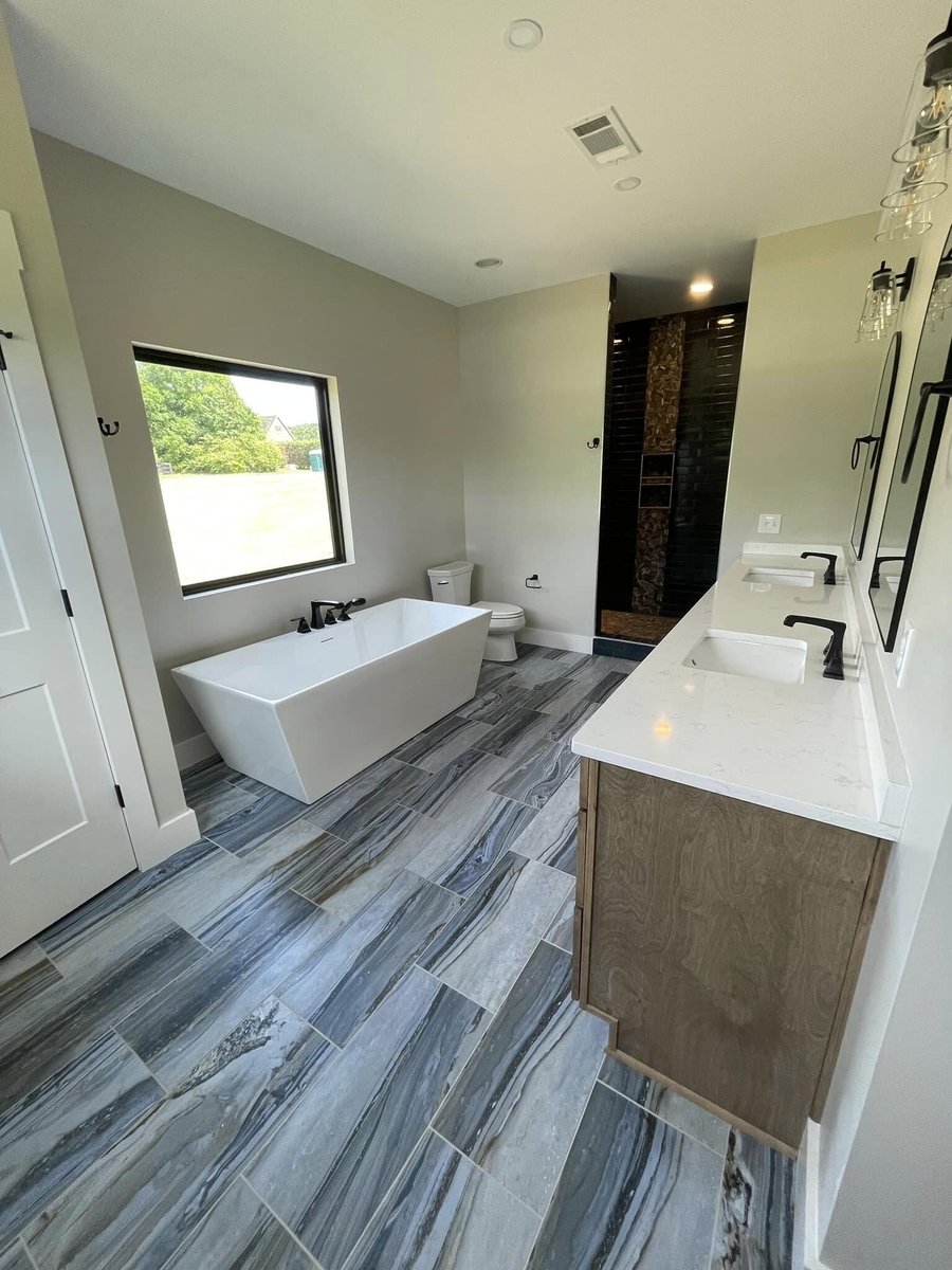 Luxurious bathroom with standalone tub and custom tile flooring by Debuty Builders in Knoxville, TN