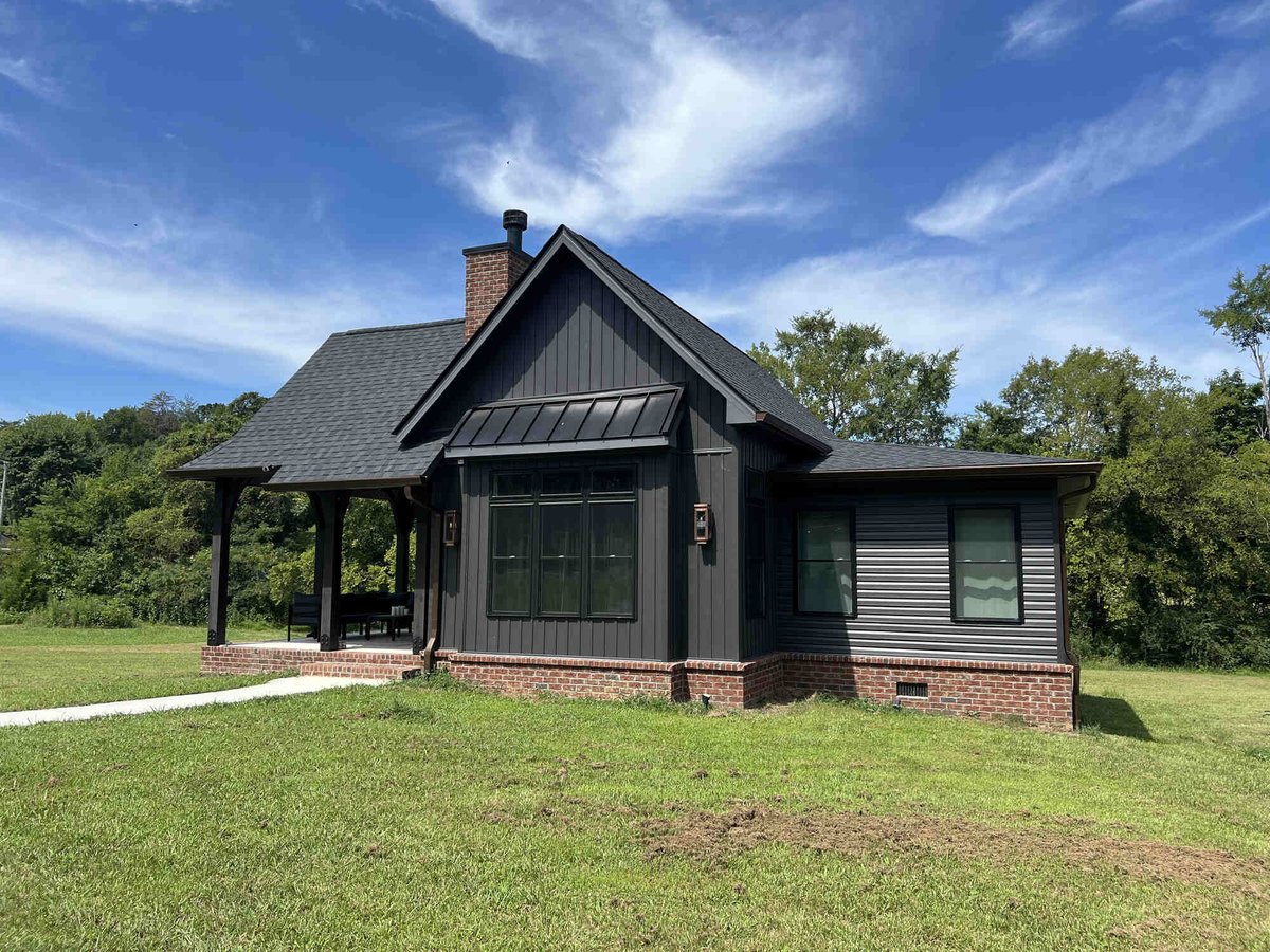 Exterior view of a custom home with dark siding and brick accents by Debuty Builders, Knoxville, TN