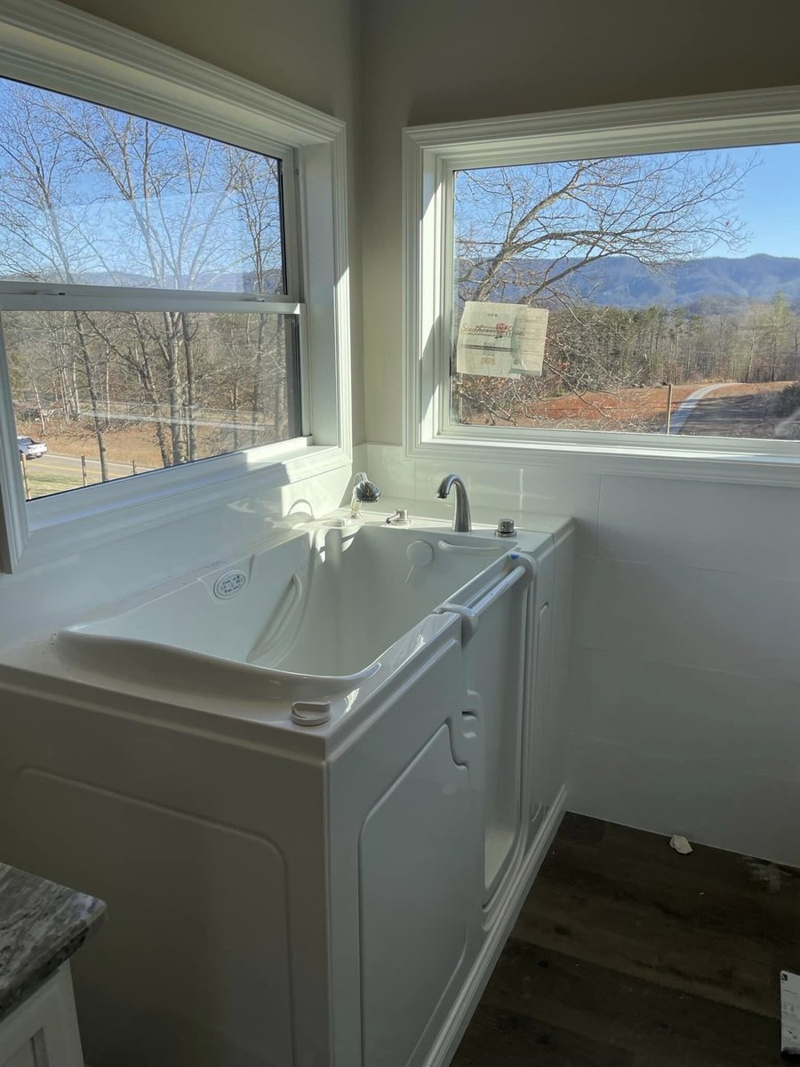 Custom home bathroom with a walk-in tub and scenic mountain views by Debuty Builders in Knoxville, TN