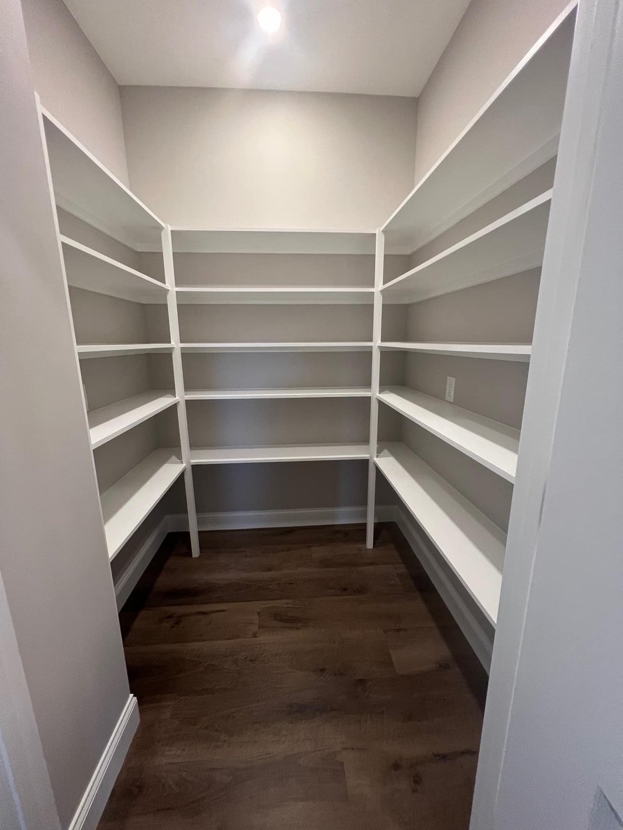 Custom-built pantry with white shelving in a Knoxville home by Debuty Builders
