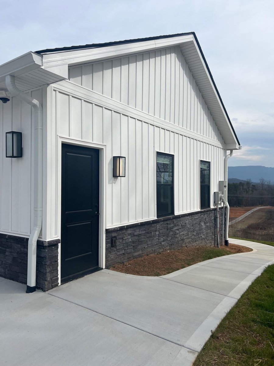 Exterior side view of a custom modern farmhouse with white siding by Debuty Builders in Knoxville, TN