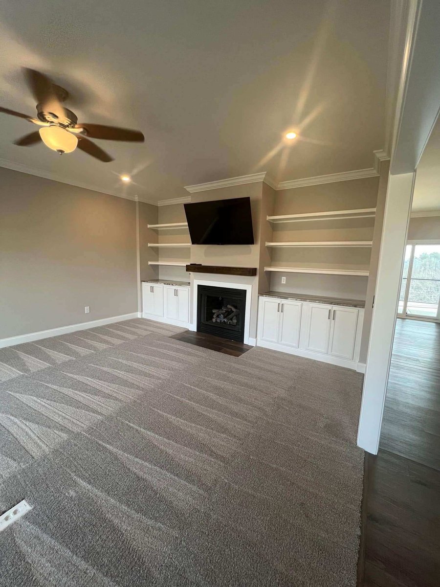 Living room with built-in shelving and a fireplace by Debuty Builders in a custom Knoxville home