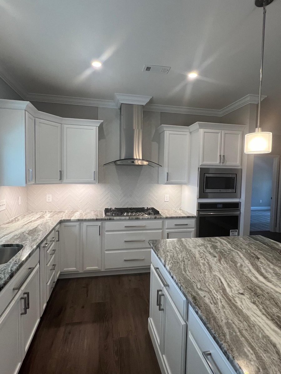 Modern kitchen with marble countertops and stainless steel appliances by Debuty Builders in Knoxville, TN