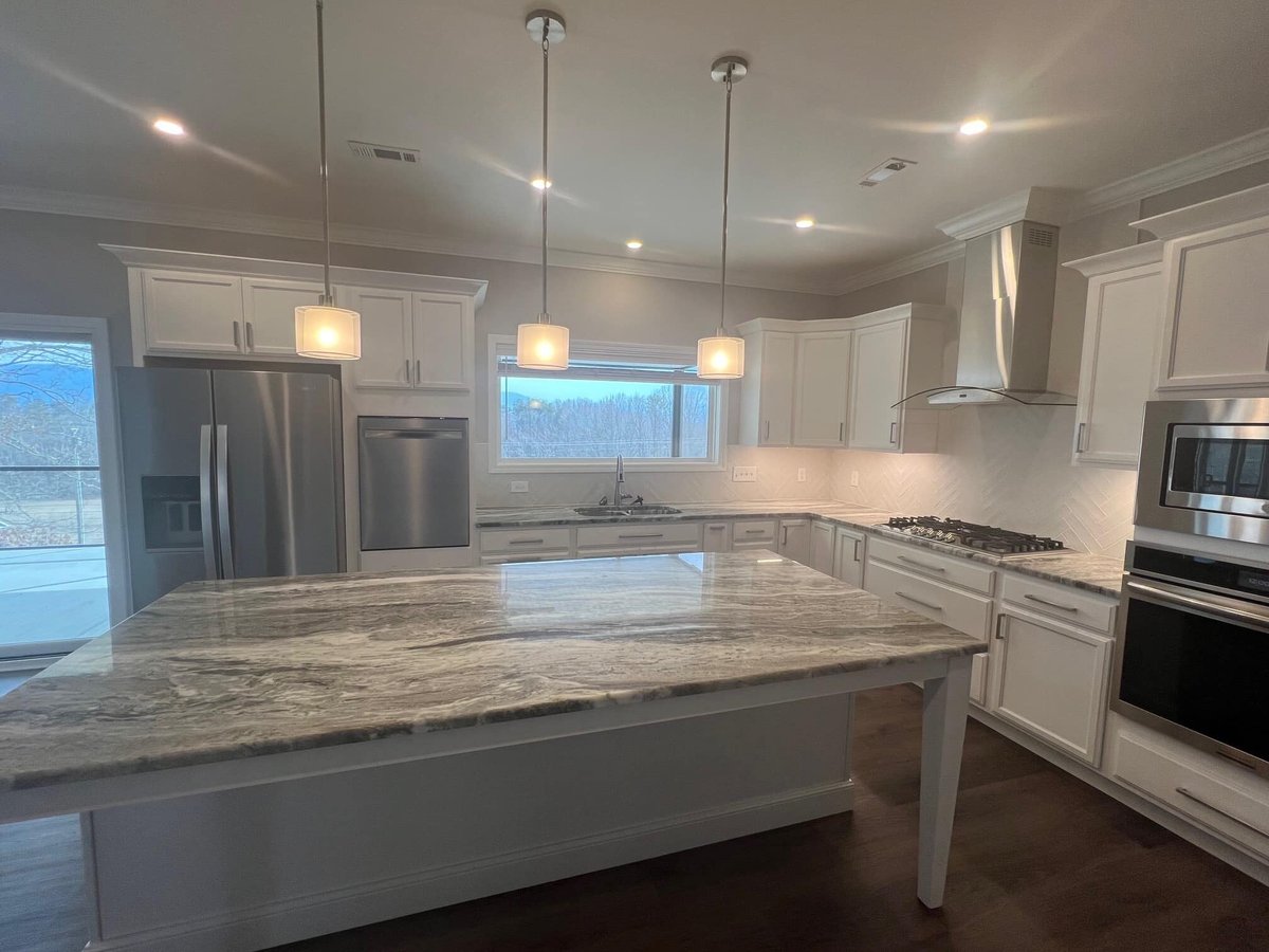 Spacious custom kitchen with marble countertops and stainless steel appliances by Debuty Builders, Knoxville, TN