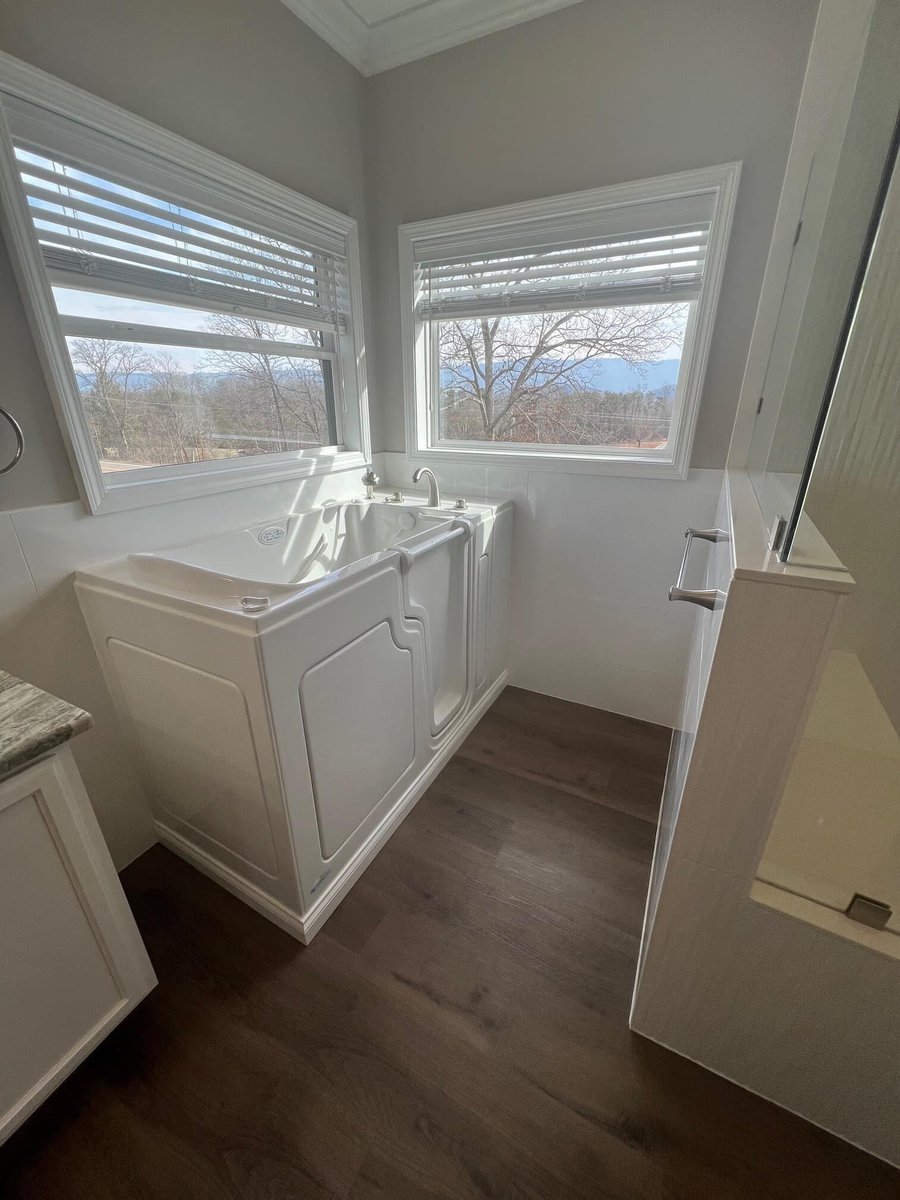 Walk-in tub in a custom bathroom by Debuty Builders with large windows showcasing mountain views, Knoxville, TN