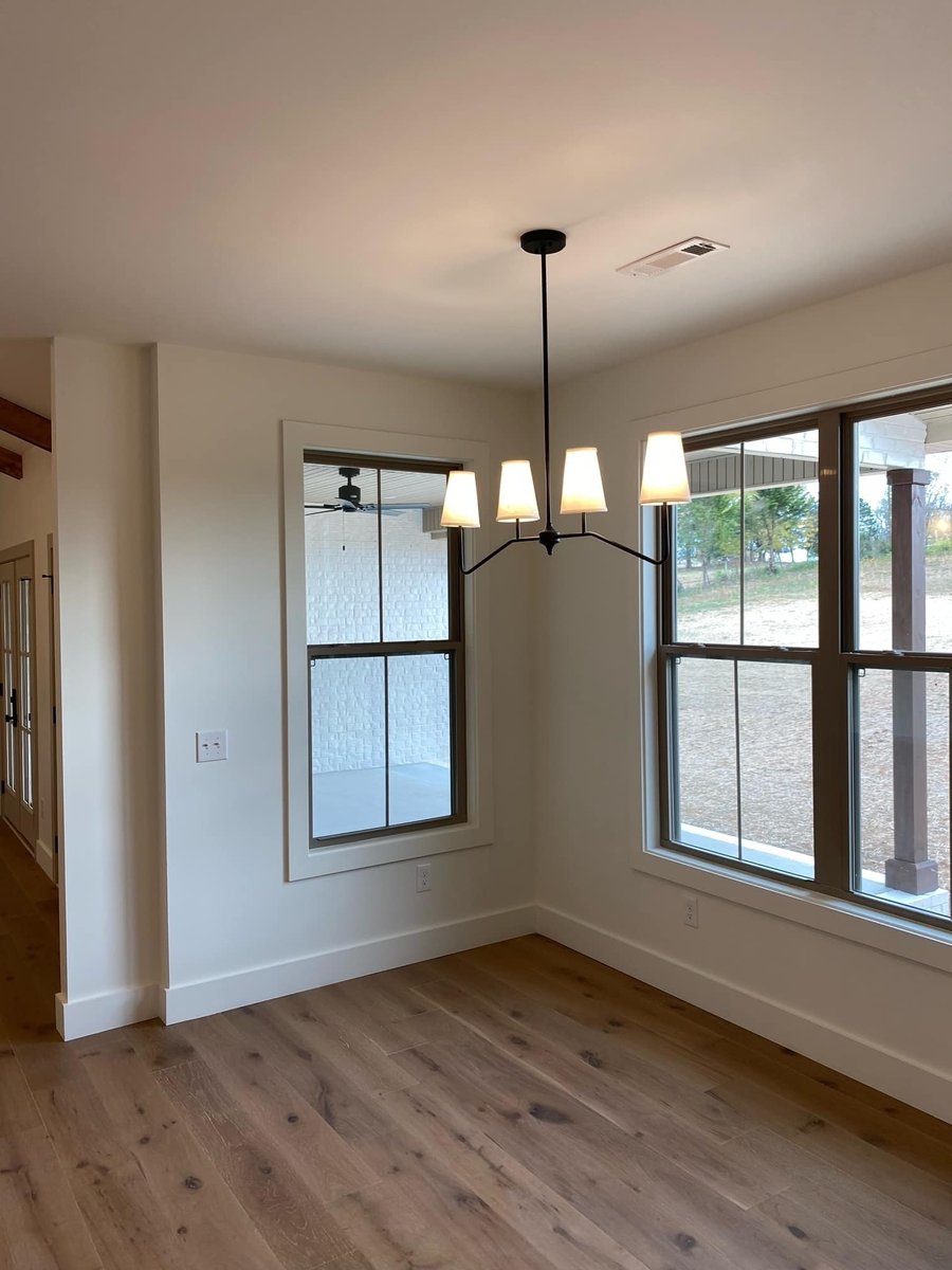 Dining room with large windows and modern black chandelier in a custom home by Debuty Builders in Knoxville, TN