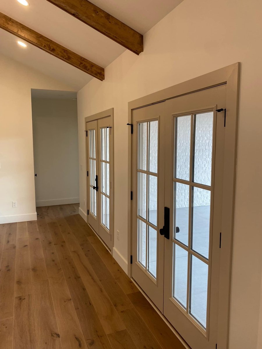 Double glass doors with wooden beams in ceiling of a custom home by Debuty Builders, Knoxville, TN