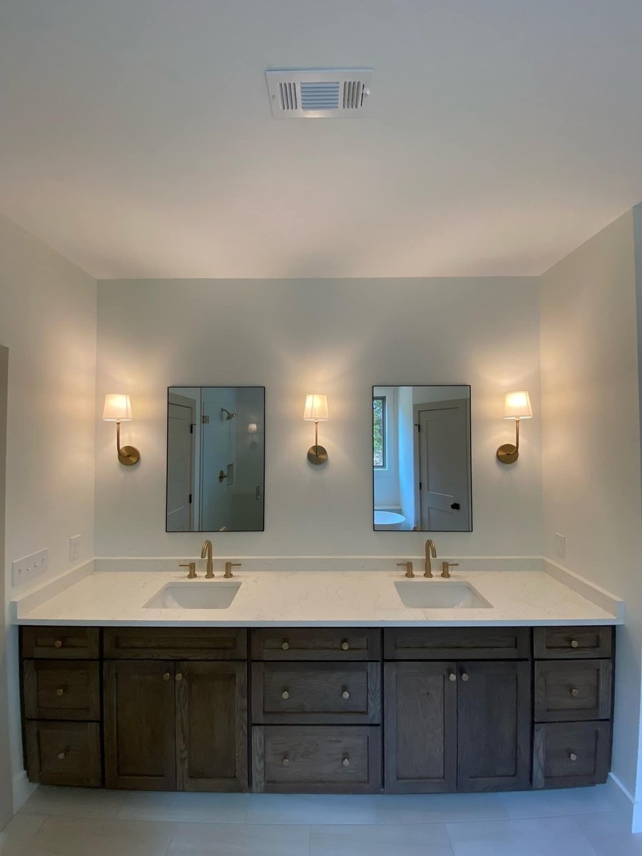 Double sink vanity with brass fixtures in a custom bathroom by Debuty Builders, Knoxville, TN