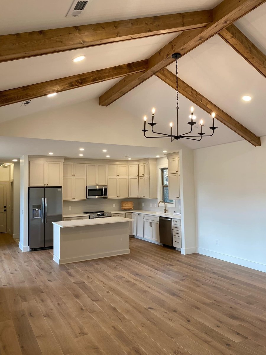 Open kitchen with vaulted ceilings and wooden beams in a custom home by Debuty Builders, Knoxville, TN