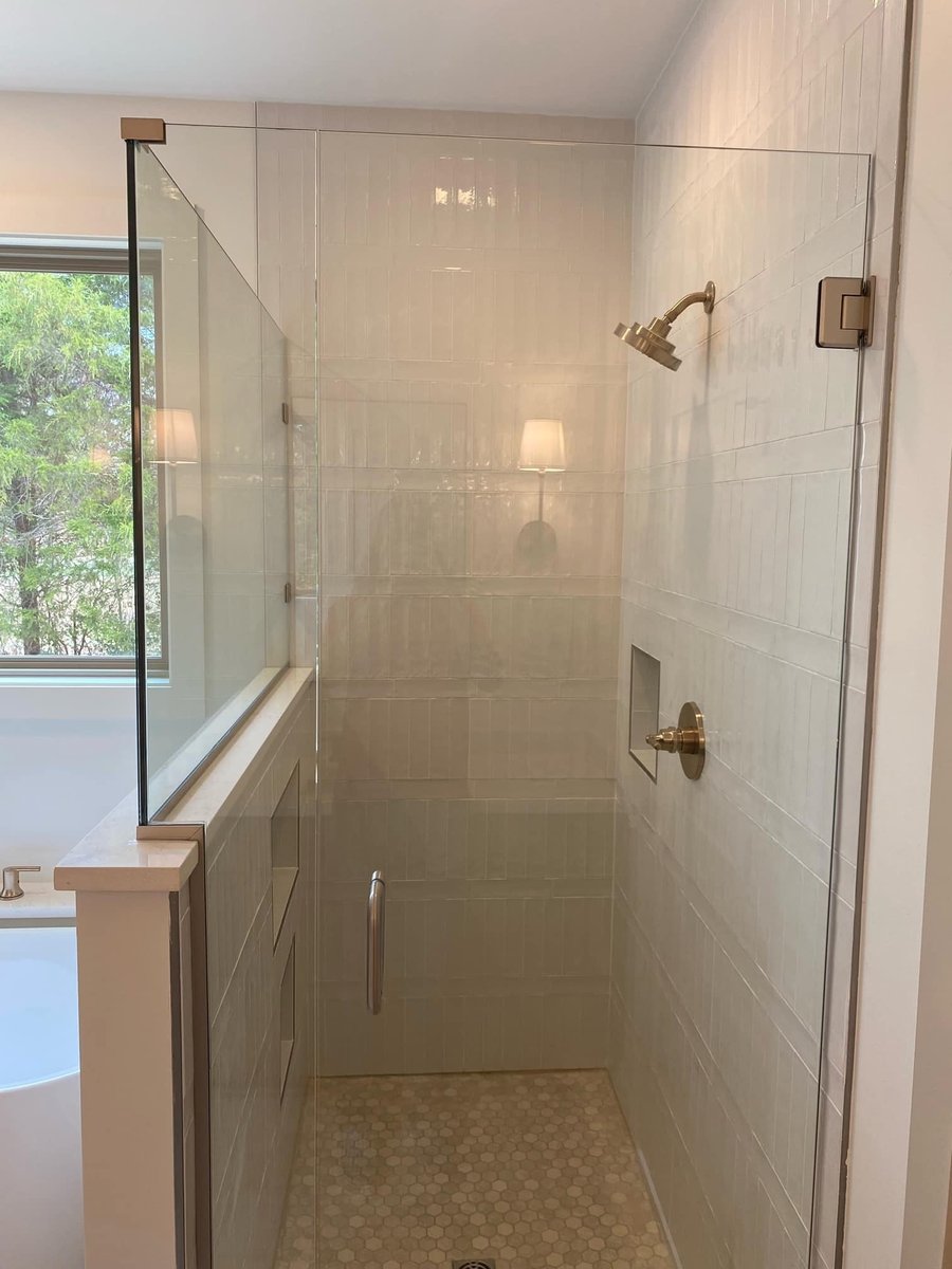 Walk-in shower with glass enclosure and honeycomb tile floor in a custom home by Debuty Builders, Knoxville, TN