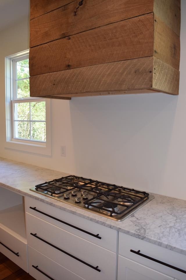 Custom kitchen with a wooden range hood and marble countertop by Debuty Builders, Knoxville, TN