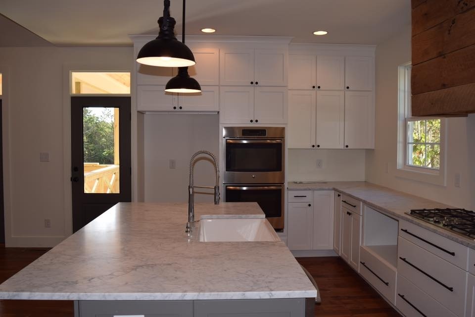 Custom kitchen with white cabinetry and marble countertops in a home by Debuty Builders, Knoxville, TN