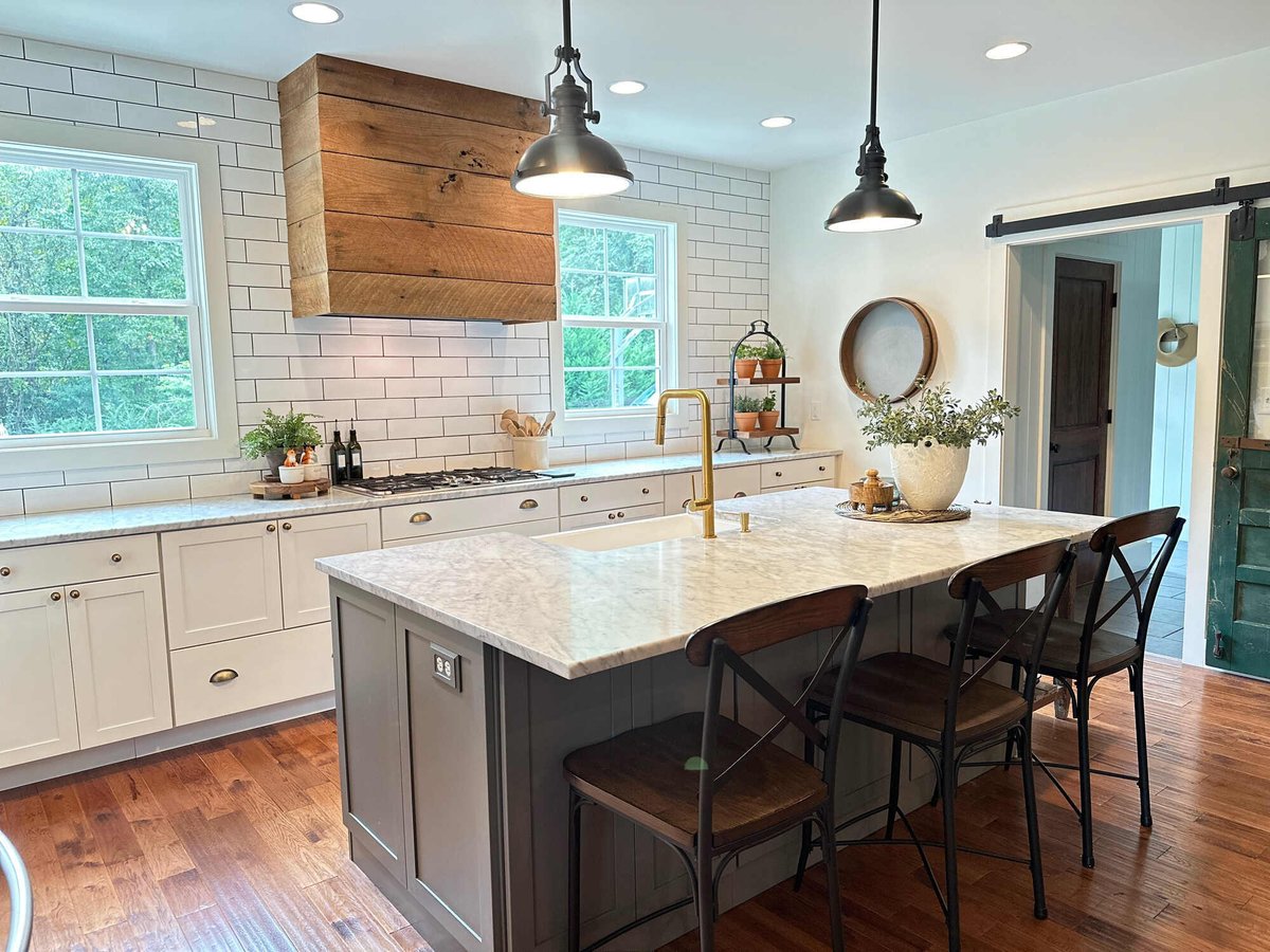 Farmhouse-style kitchen with marble island and rustic wooden accents by Debuty Builders, Knoxville, TN