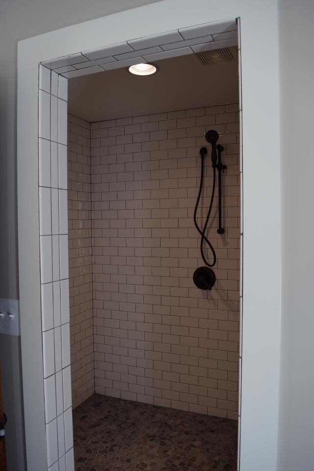 Modern tiled shower with black fixtures in a custom home by Debuty Builders, Knoxville, TN