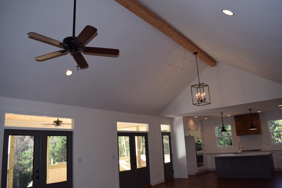 Open concept living room and kitchen with vaulted ceilings and ceiling fans in a custom home by Debuty Builders, Knoxville, TN