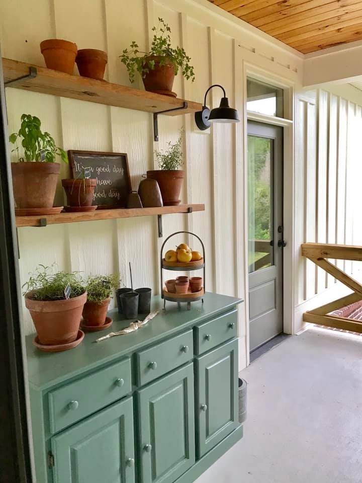Outdoor porch space with potted plants and wooden shelves in a custom home by Debuty Builders, Knoxville, TN