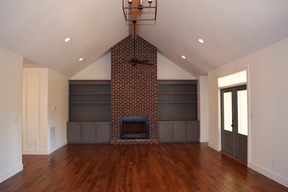 Spacious living room with a brick fireplace in a custom home by Debuty Builders, Knoxville, TN