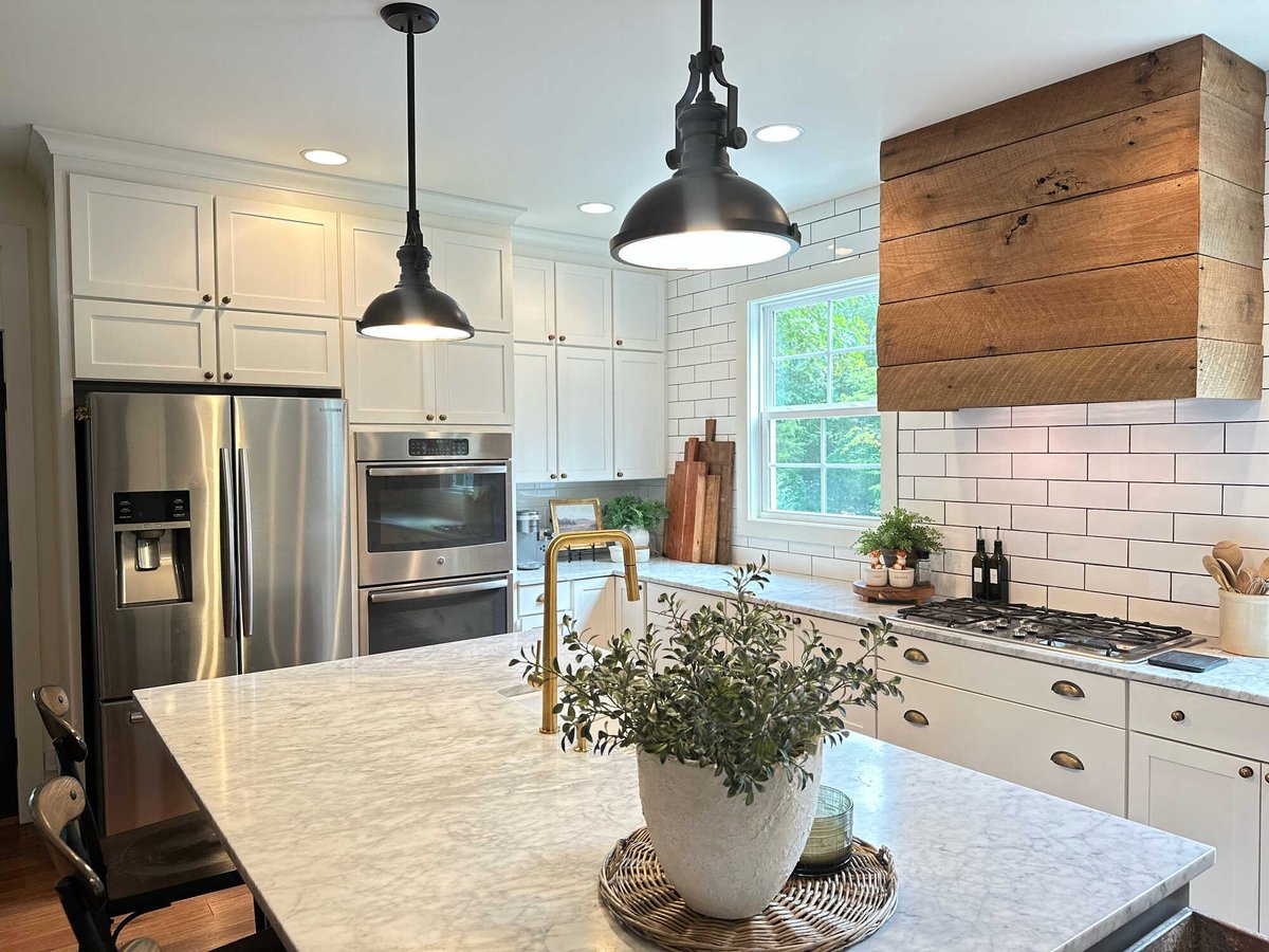 White cabinetry and rustic wood range hood in a modern kitchen by Debuty Builders, Knoxville, TN