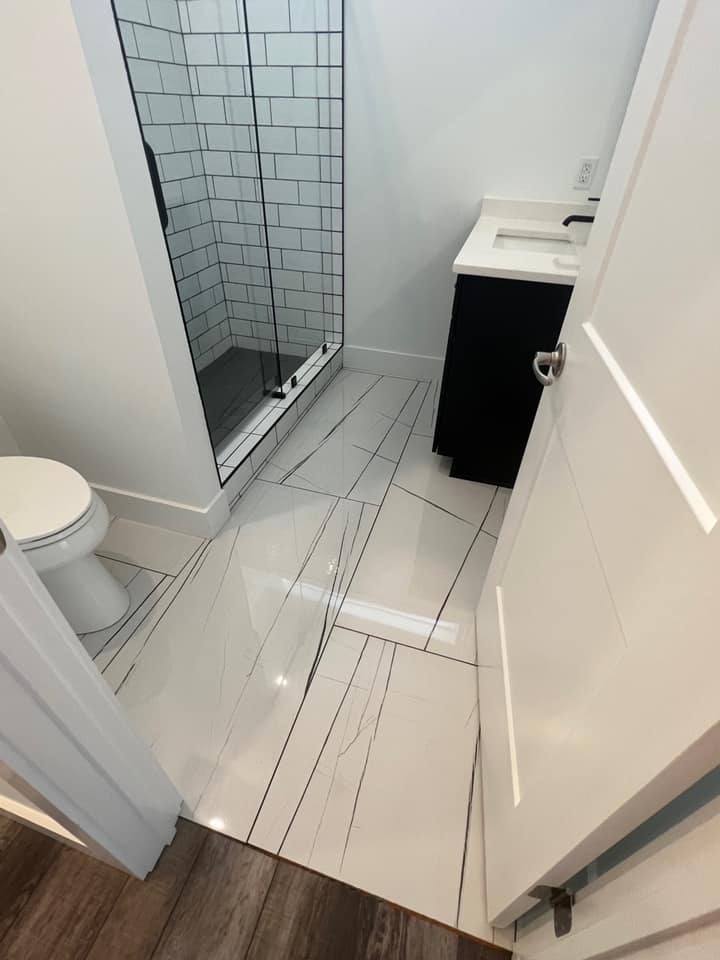 Compact bathroom with glass shower and modern tile flooring in a custom home by Debuty Builders, Knoxville, TN