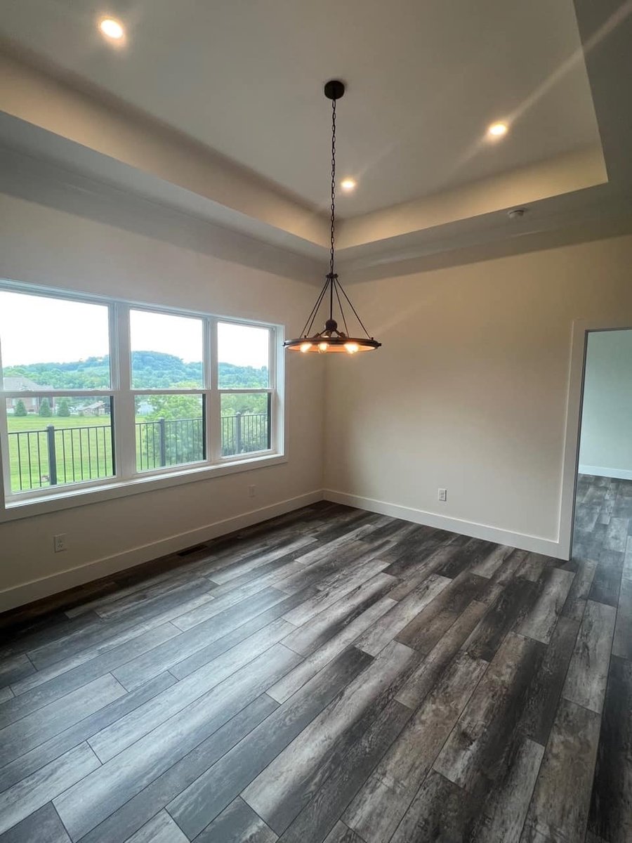 Dining room with tray ceiling and large windows in a custom home by Debuty Builders, Knoxville, TN