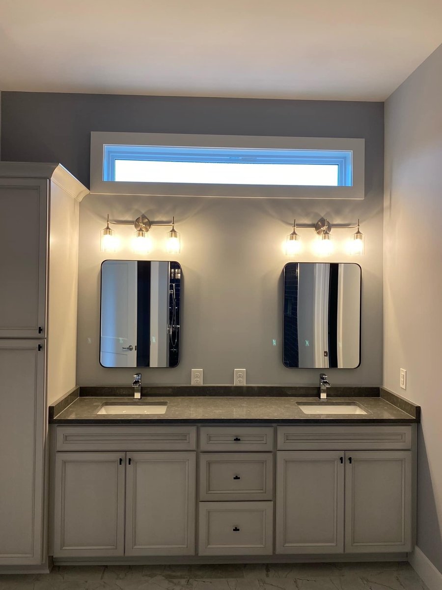 Double vanity bathroom with large mirrors and overhead lighting in a custom home by Debuty Builders, Knoxville, TN