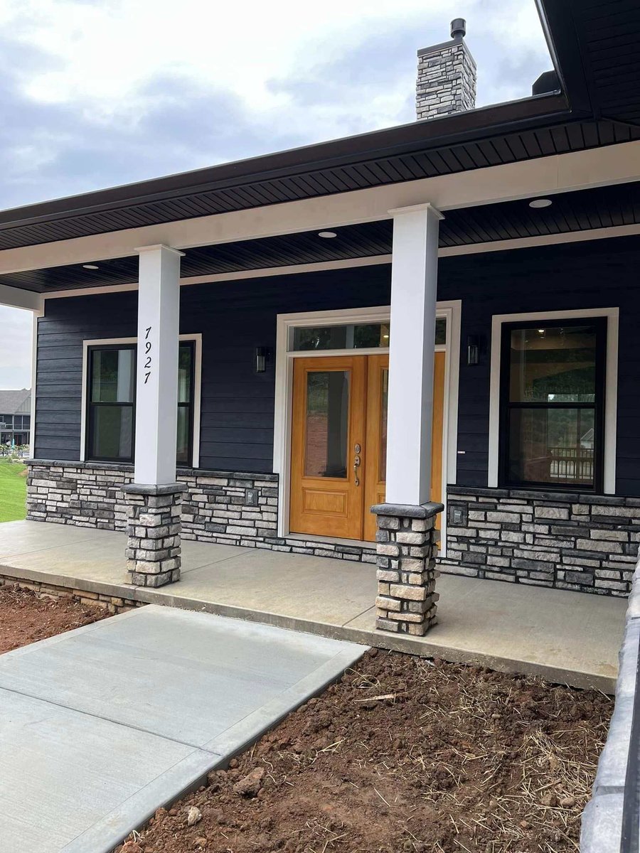 Front porch with stone columns and wooden door on a custom home by Debuty Builders, Knoxville, TN